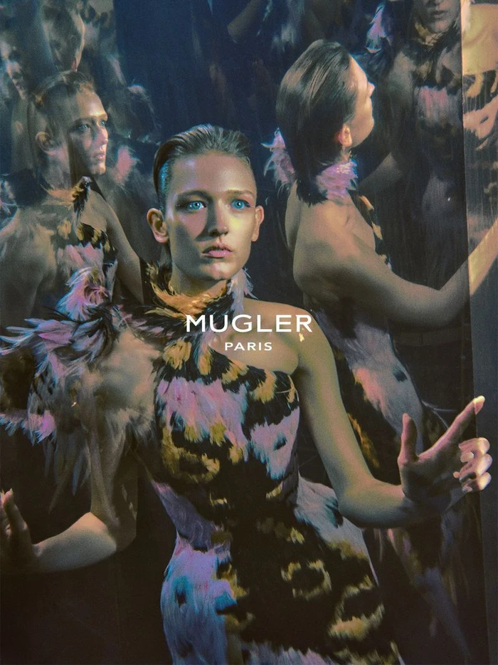 Model in a patterned feather dress with multiple overlapping exposures against a dark background