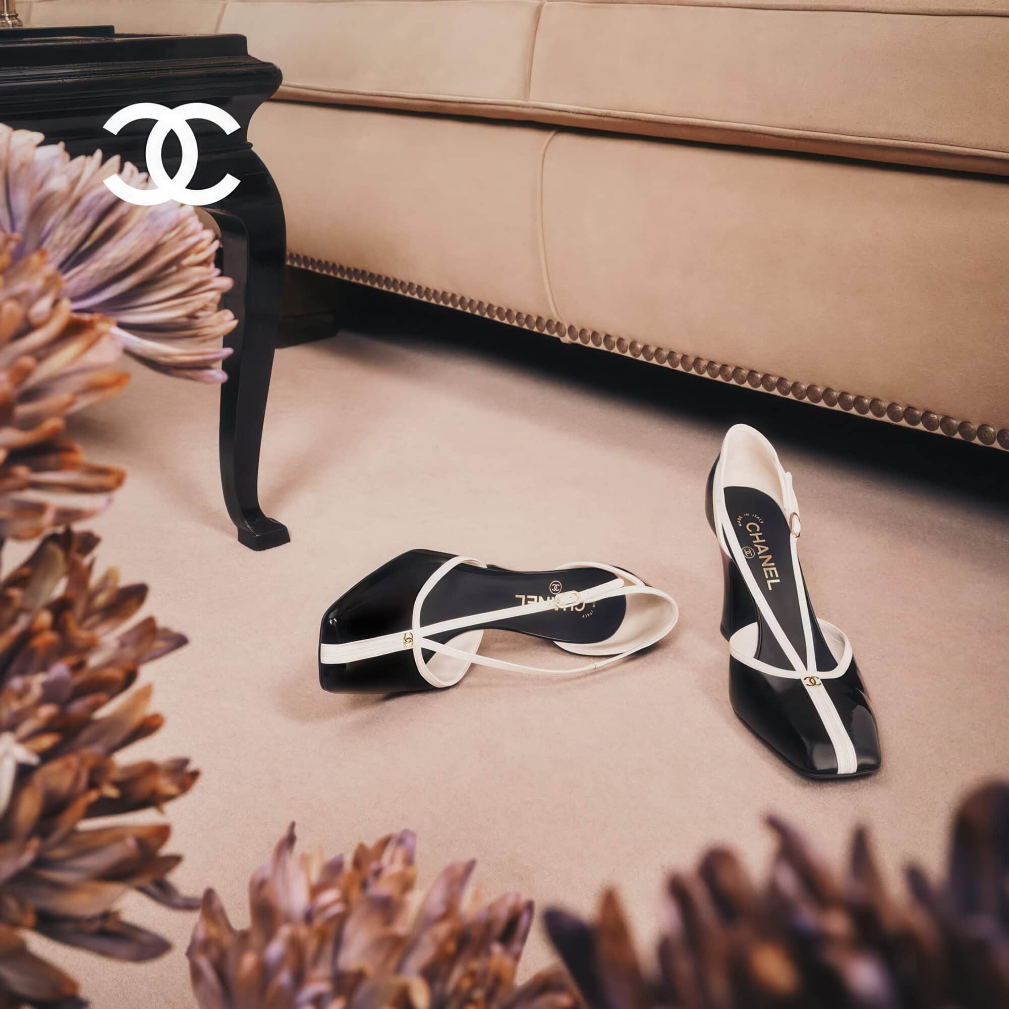 Two-tone black and white slingback heels resting on a beige carpet near a couch and dark wooden table
