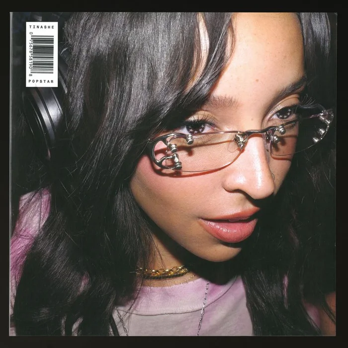 Tinashe wearing frameless metal glasses and headphones for an album cover portrait by Hugo Comte.