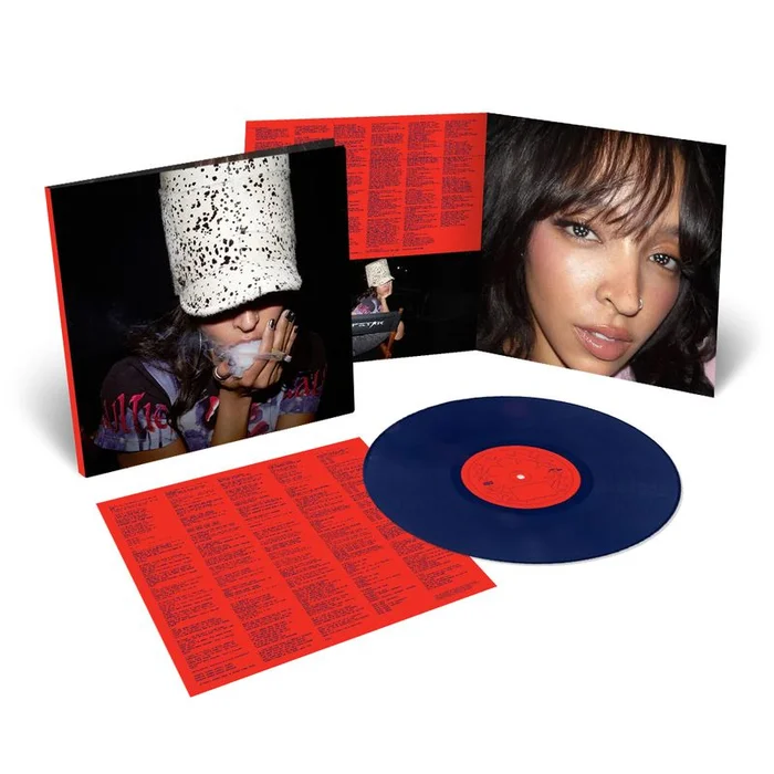 Tinashe vinyl album package with a dark blue record, red lyric inserts, and open gatefold jacket against white background