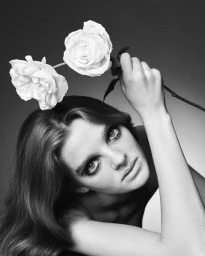 Model holding two white roses above her head in a black and white fashion portrait for Chloé Summer 27