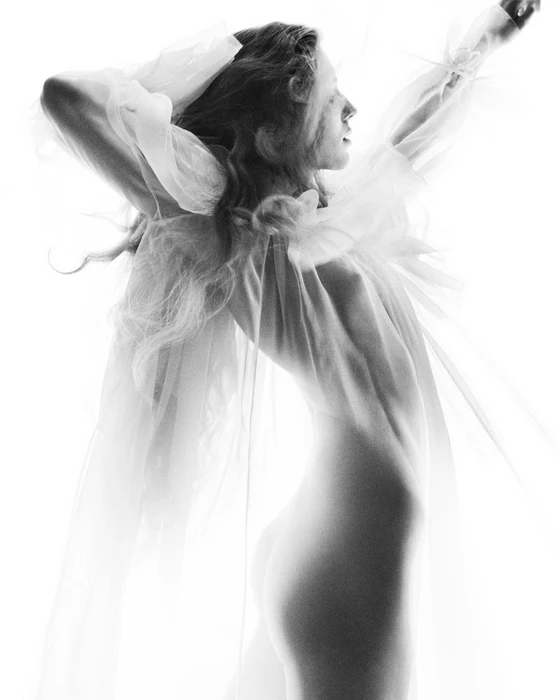Model in sheer white ruffled top posing against a bright white background for Chloé Summer '27