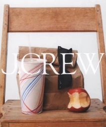 A brown paper lunch bag, a striped drink cup, sunglasses, and a bitten apple sitting on a wooden chair.