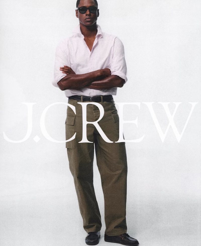 Man wearing sunglasses, white button-down shirt, and olive cargo pants standing against a plain white background with J. Crew text overlay.