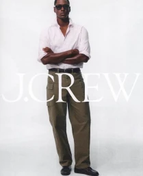 Man wearing sunglasses, white button-down shirt, and olive cargo pants standing against a plain white background with J. Crew text overlay.