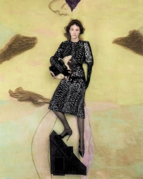 Hunter Schafer wearing a black patterned dress standing on a small dark triangular structure against a painted textured background