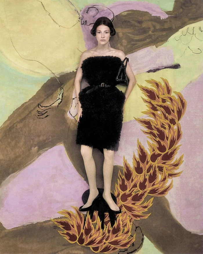 Hunter Schafer standing against a hand-painted backdrop wearing a black textured strapless dress for Elle U.S.
