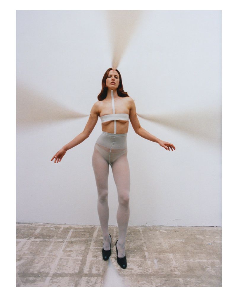 Model Julia Banas in white tights and taped top with streams of sand radiating out for Middle Plane Issue 13