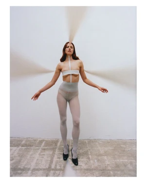 Model Julia Banas in white tights and taped top with streams of sand radiating out for Middle Plane Issue 13