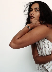 Model Ylang Messenguiral wearing a patterned white dress with a bracelet for M Le magazine du Monde