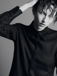 Model with wet hair wearing a black long-sleeve button-up shirt against a plain grey backdrop.
