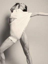 Model in white draped apparel striking a dynamic dynamic pose against a neutral background for Kallmeyer