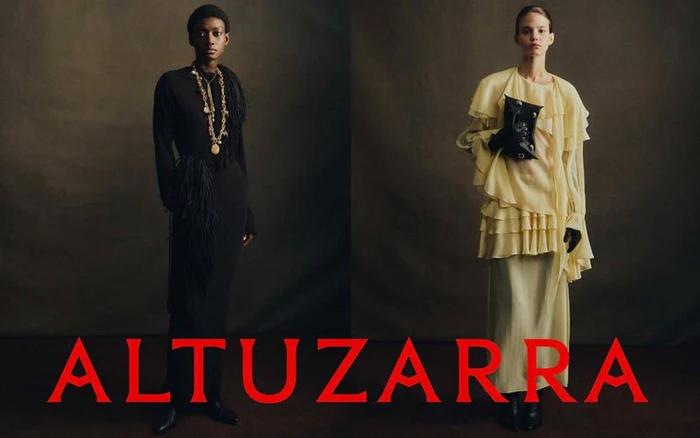 Two models showcasing Altuzarra Fall 2026 collection against dark textured backdrop with bold red brand typography