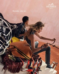 A female model posing outdoors alongside a man, surrounded by luxury leather bags and silk scarves for Hermes.