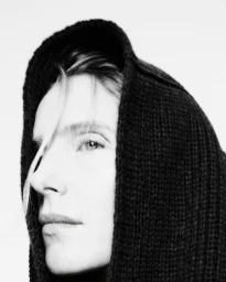 Close-up portrait of Dree Hemingway wearing a black knitted hood against a white background for Nami