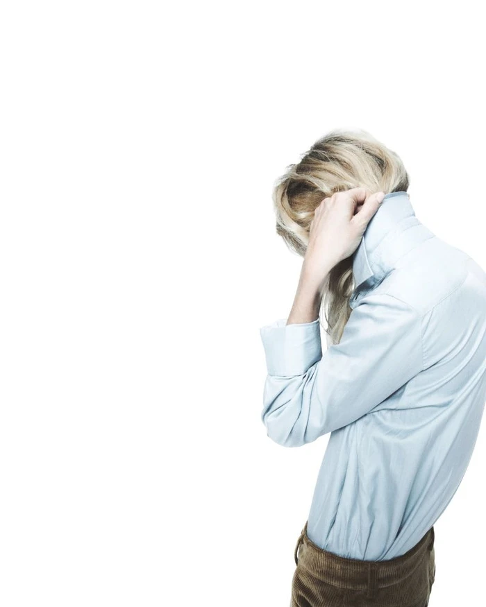 Dree Hemingway wearing a light blue collared shirt and brown trousers against a white seamless background for Nami