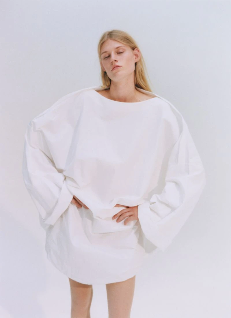 Model Bodine Van Galen wearing an oversized white dress against a plain white backdrop for D Repubblica