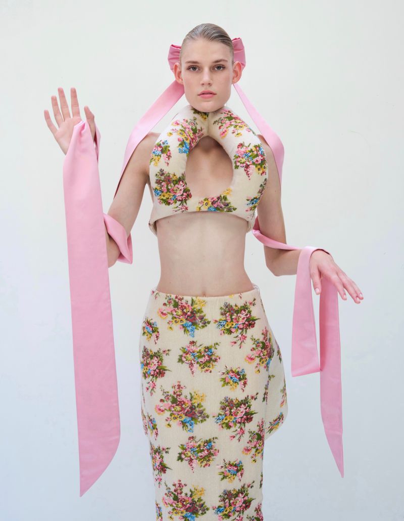 Model Bodine Van Galen in a floral print cutout top and matching skirt with long pink ribbons for Vogue China