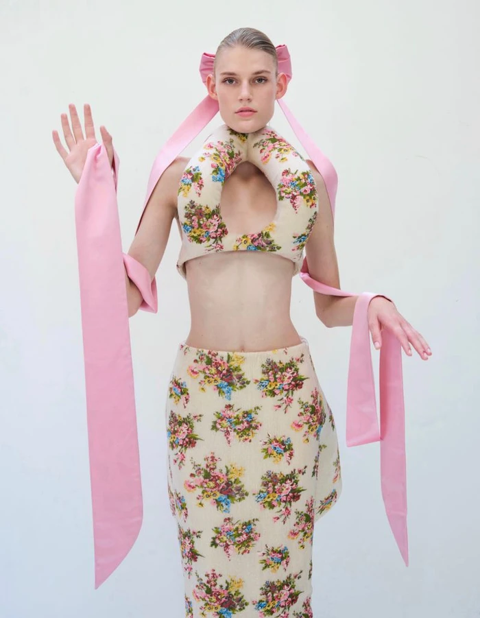 Model Bodine Van Galen in a floral print cutout top and matching skirt with long pink ribbons for Vogue China