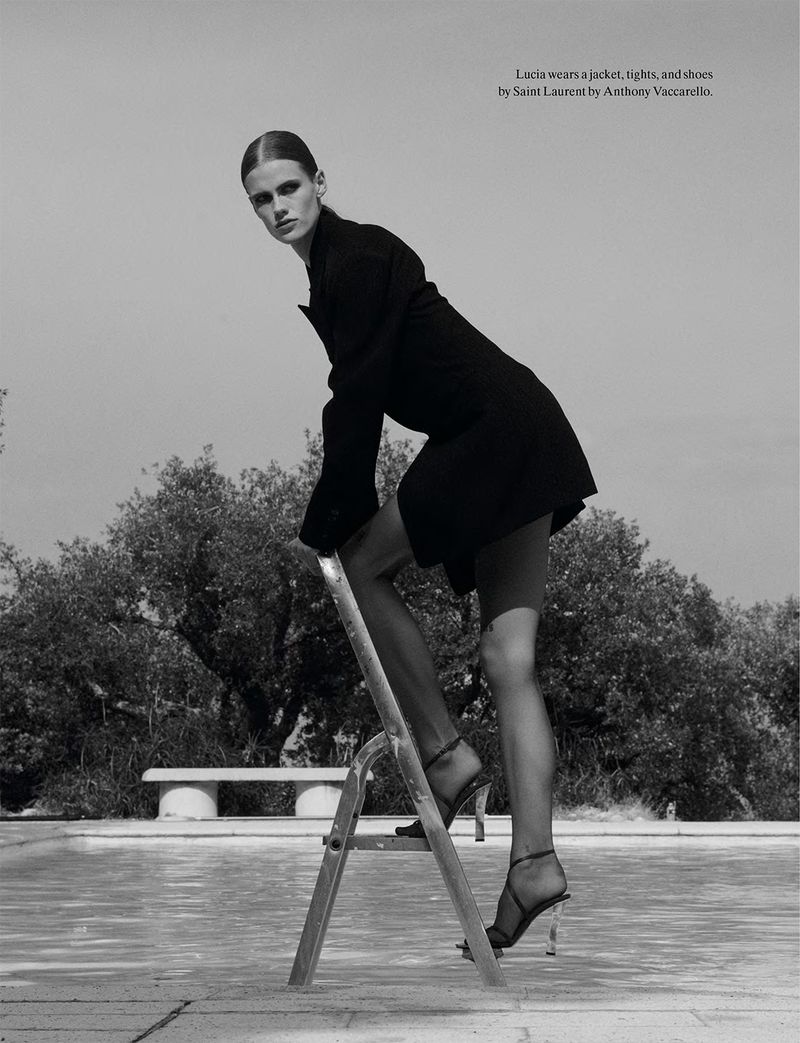 Model Lucia Richardson wearing black jacket and heels on a pool ladder for System Magazine