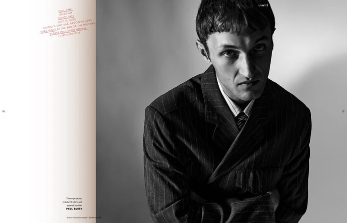 Anwar Hadid in a pinstripe jacket and collared shirt against a plain studio background for Archives Futures.