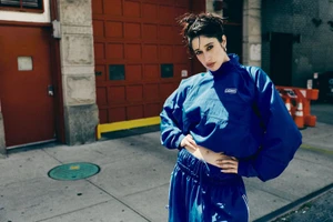 Woman in a blue track suit standing on a city sidewalk in front of a red door for Imagine Magazine shot by Brendan Wixted.