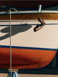 Brown leather boat shoes hanging by their laces from the gunwale of a wooden boat with a white and orange hull