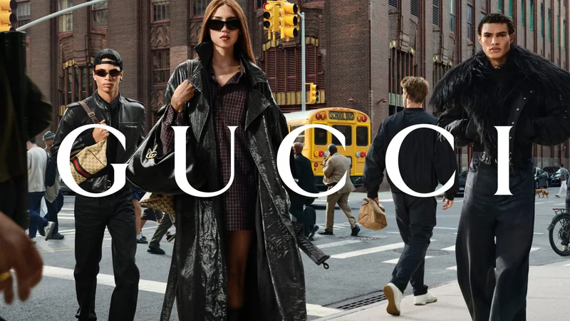 Three fashion models in dark attire and sunglasses walking down a bustling New York City street with a yellow school bus in the background