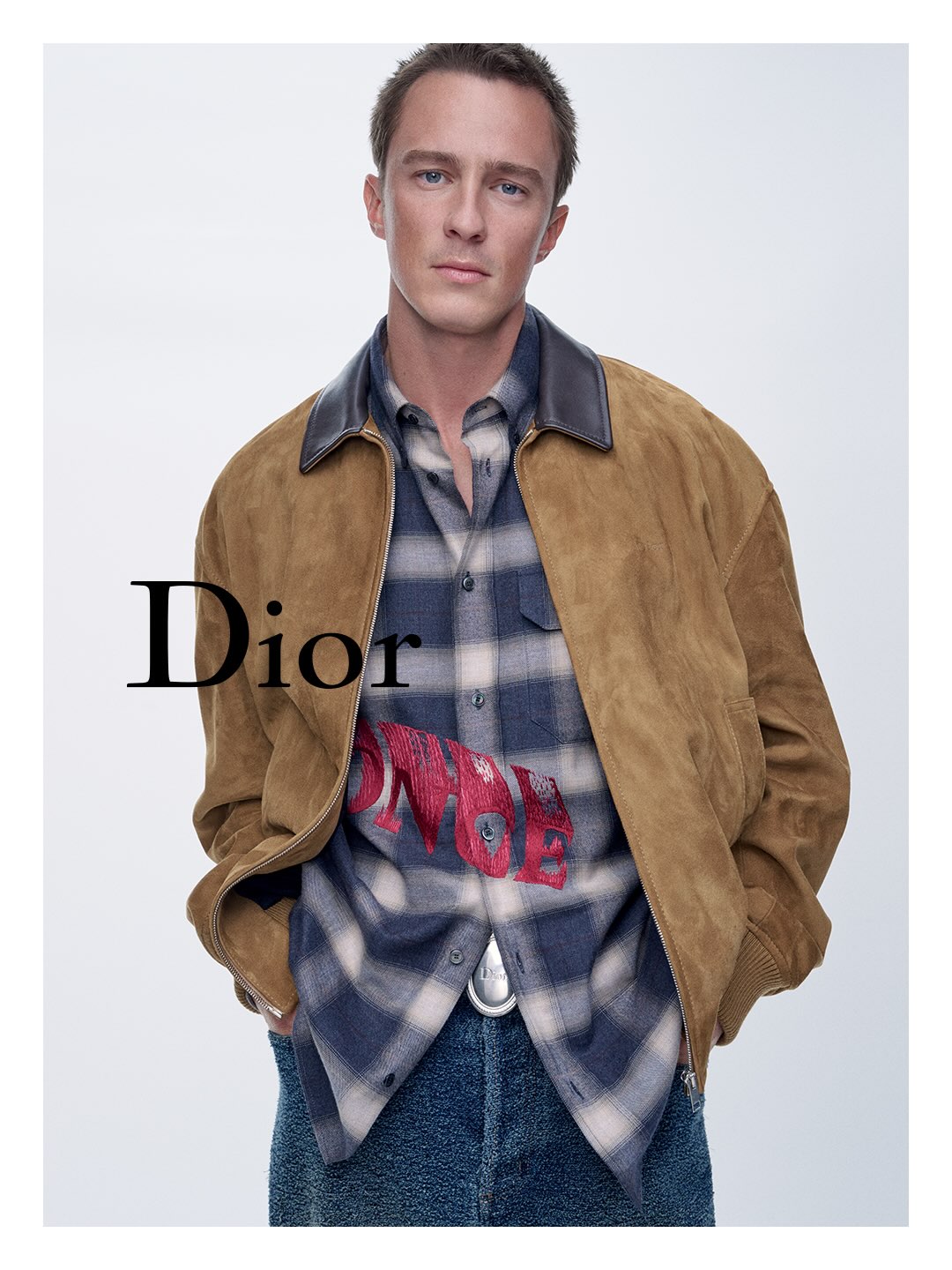 Drew Starkey in a camel suede jacket and plaid shirt for Dior Cruise 2027 campaign photographed by Sam Rock