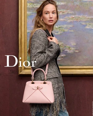 Jennifer Lawrence in a tweed fringed jacket holding a pink handbag for Dior Cruise 2027