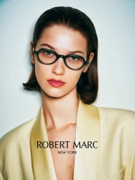 Model wearing dark glasses and a pale yellow jacket against a light background for Robert Marc