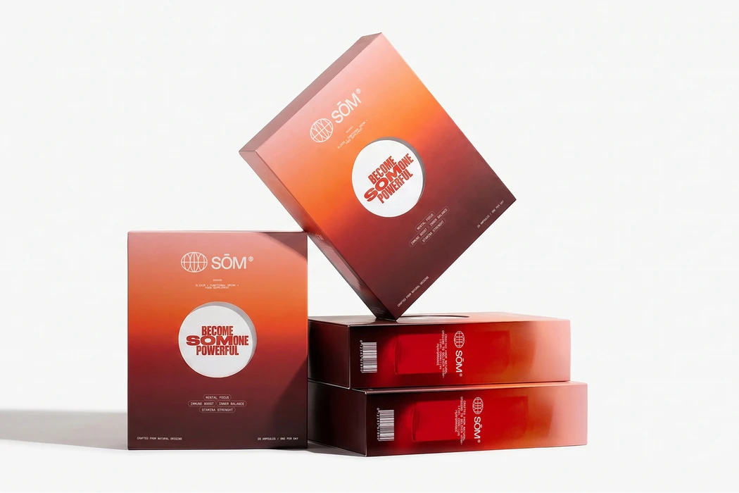 Product packaging boxes for SŁM daily elixir shots featuring red and orange gradient designs on a white surface
