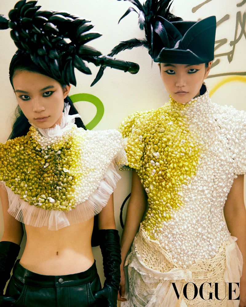 Two female models in avant-garde textured tops and dramatic black headpieces for a Vogue Korea editorial shoot