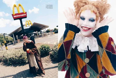 Model dressed in clown makeup and patterned velvet harlequin jacket posing outside McDonald's in More or Less Magazine editorial