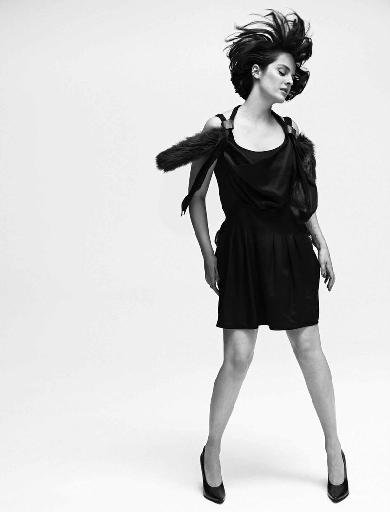 Noemie Merlant in a black mini dress with fur trim detail against a white studio background for Madame Figaro editorial