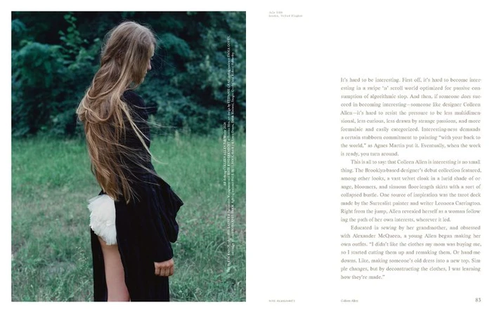 Profile shot of a woman with long hair wearing a black garment and white bloomers standing before a dense green forest