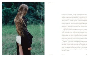 Profile shot of a woman with long hair wearing a black garment and white bloomers standing before a dense green forest