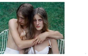 Two young people embracing closely on a white wire garden chair against a green lawn background for Crosscurrent by Senta Simond.