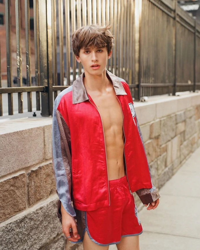 Josiah Turner posing outdoors in red jacket and matching shorts for GQ Turkey by photographer Jasper Soloff