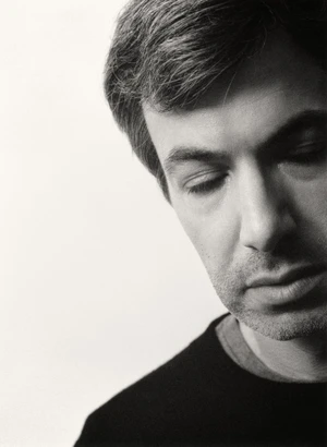 Close-up monochrome portrait of Nathan Fielder looking down against a plain white background