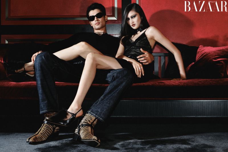Two models posing on a red sofa for Harper's Bazaar China editorial photographed by Haiyang York