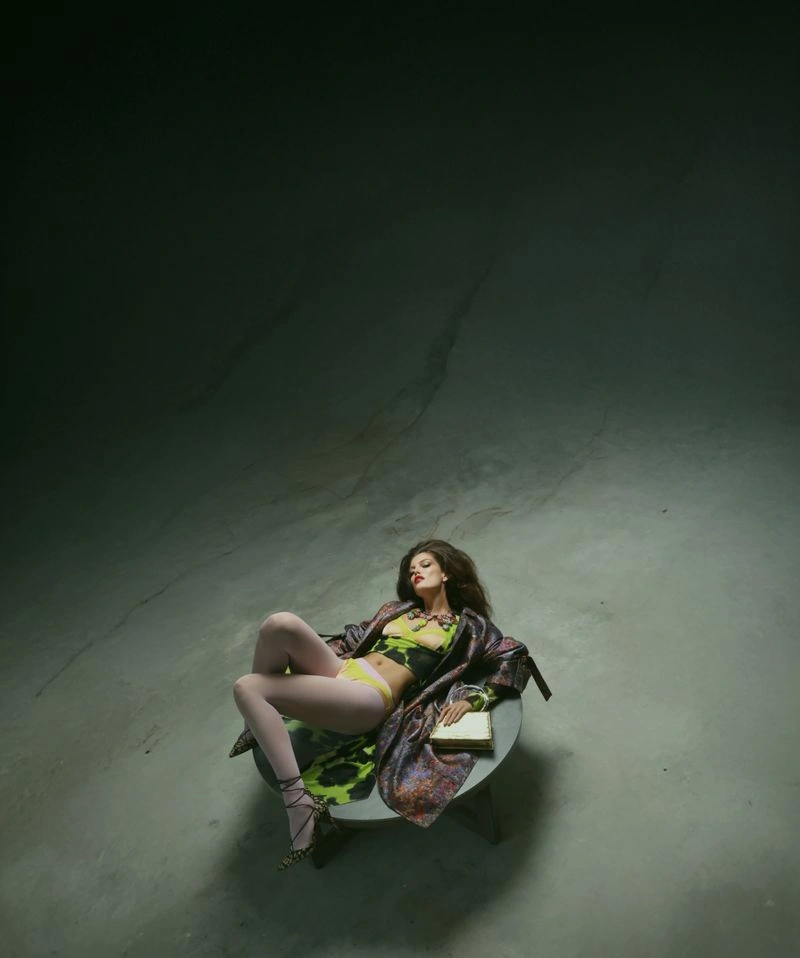 Model Vanessa Fuchs lying on a circular platform in a dimly lit studio for Numéro Switzerland
