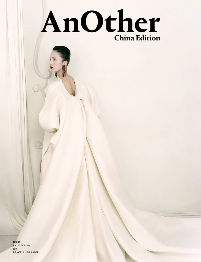 Model in a voluminous white gown with a sweeping train standing against a light background for AnOther China Edition
