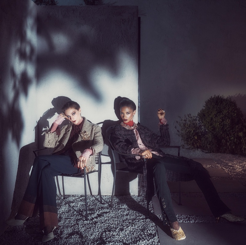 Two women seated in outdoor chairs against a white wall with harsh leaf shadows for Zara Twilight Roses