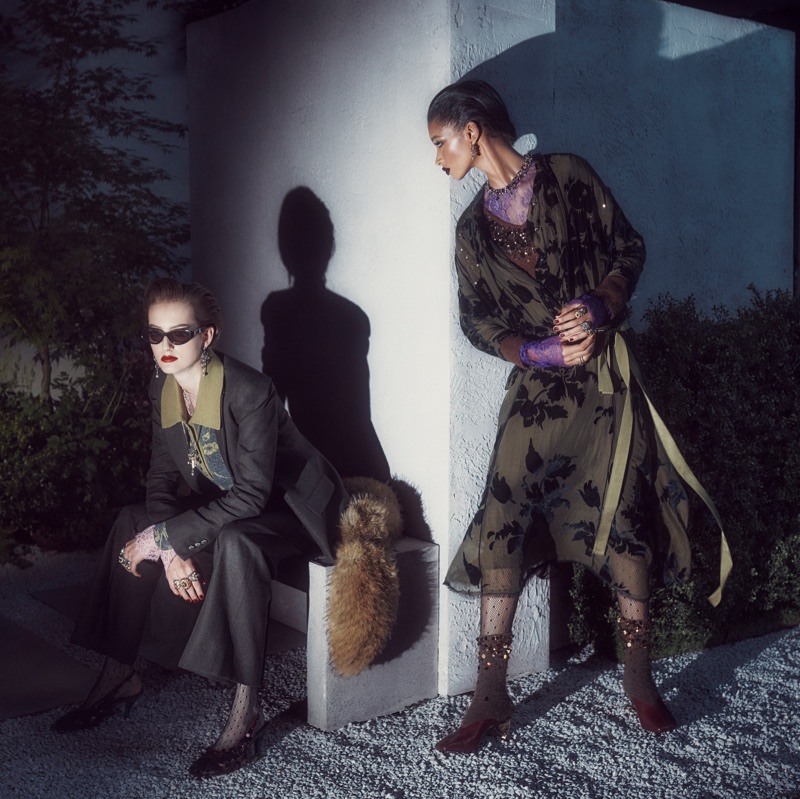 Two models in dark layered clothing outdoors at night under dramatic directional spotlighting for Zara Twilight Roses