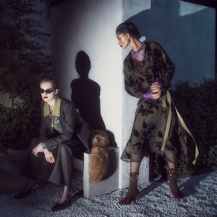 Two models in dark layered clothing outdoors at night under dramatic directional spotlighting for Zara Twilight Roses
