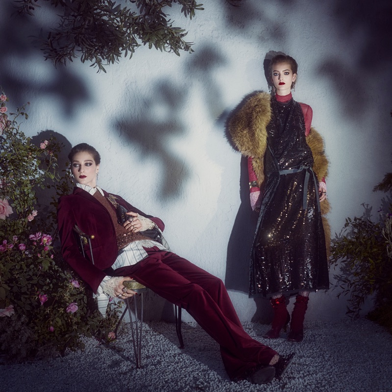 Two female models in dramatic evening wear pose outdoors against a textured wall with leaf shadows, photographed by Steven Meisel for Zara.