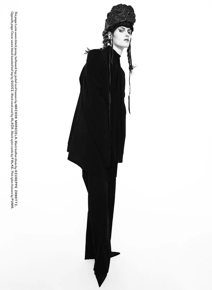 Model Lucia Richardson wearing black attire and an elaborate textured headpiece against a white background