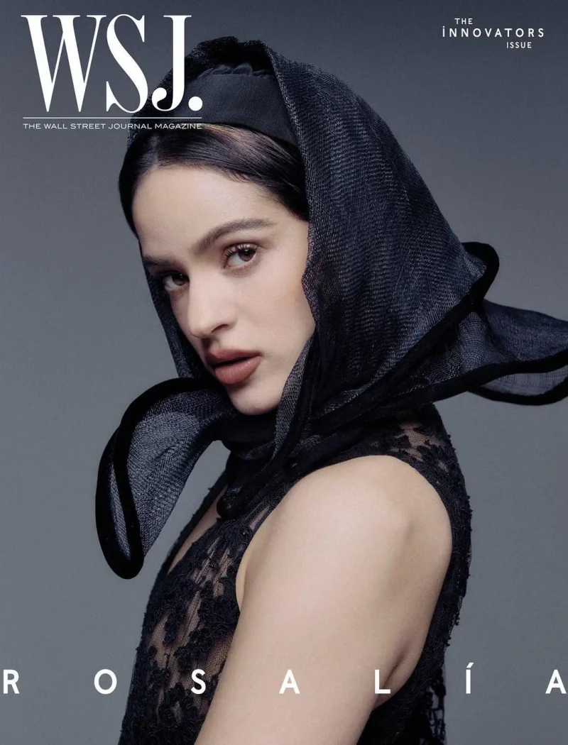 Rosalia in a black lace dress and dark sheer headscarf posing against a grey studio background for WSJ Magazine