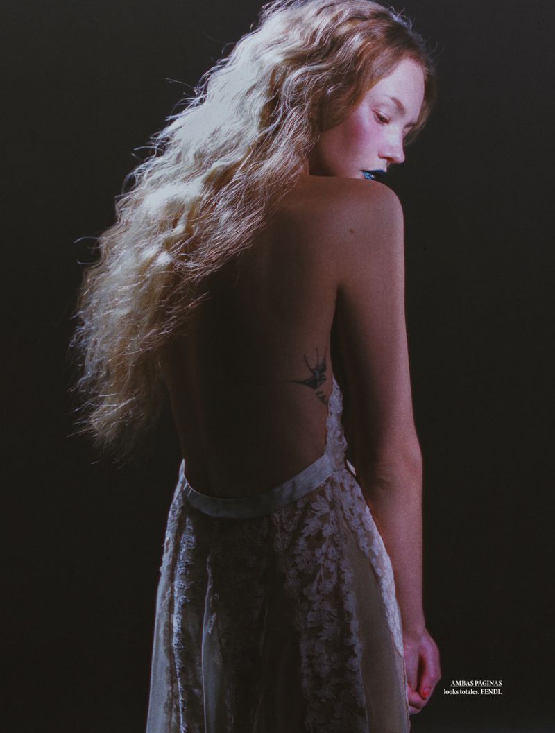 Model Katya Plotnikova in a backless lace gown against a dark background for Elle Mexico shot by Jesús Soto Fuentes